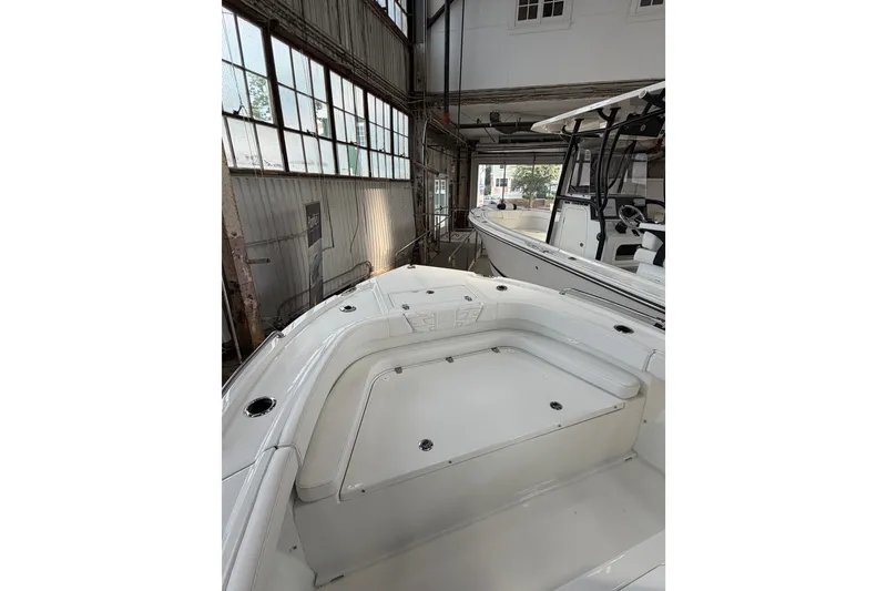 Slide: The Image of 2027 Parker 180 Coastal boat in a warehouse, showcasing sleek design and spacious deck. - 13