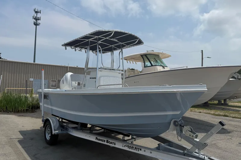 Slide: The Image of 2027 Parker 180 Coastal boat on trailer, parked outdoors under cloudy sky. - 2