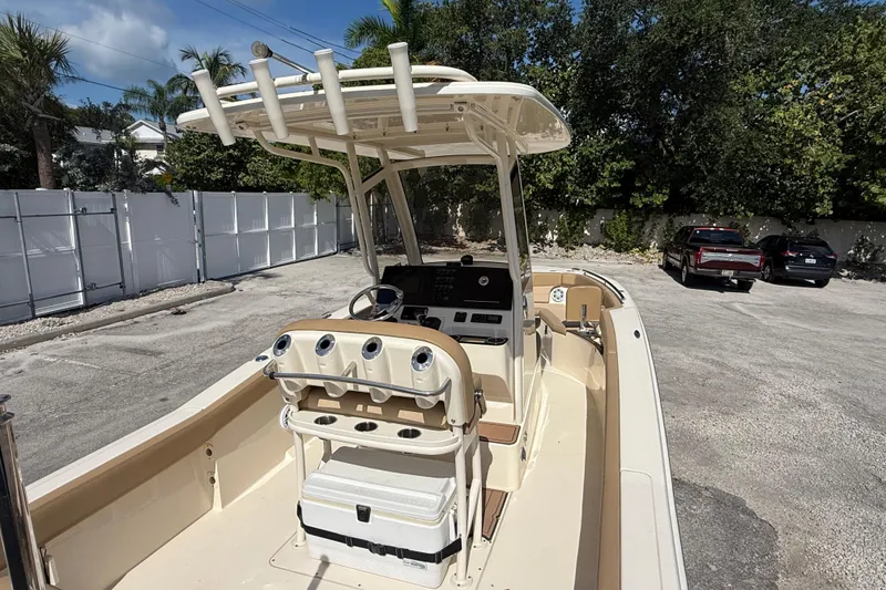 Slide: The Image of 2018 Scout 235 XSF boat with center console and T-top in a parking area. - 4
