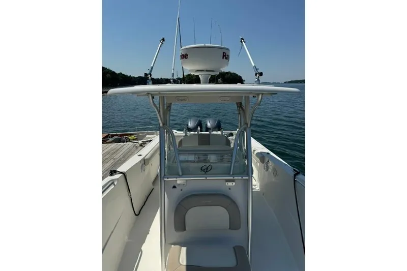 Slide: The Image of 2012 Sailfish 3180 CC boat docked on calm water, featuring a central console. - 2