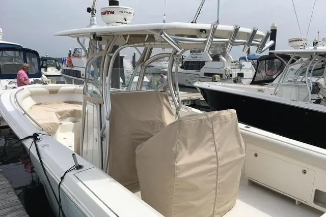 Slide: The Image of 2012 Sailfish 3180 CC boat docked, featuring covered seating and modern equipment. - 3