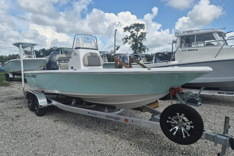 The Image of 2026 Key West 210 Bay Reef boat on trailer, parked outdoors under a cloudy sky. - 1