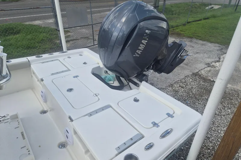 Slide: The Image of 2026 Key West 210 Bay Reef boat with Yamaha outboard motor, docked on gravel surface. - 6
