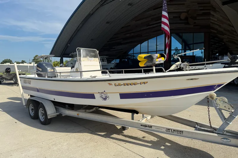 Slide: The Image of 2002 Sea Pro SV2400CC Bay Boat on trailer, parked outside a modern building. - 3