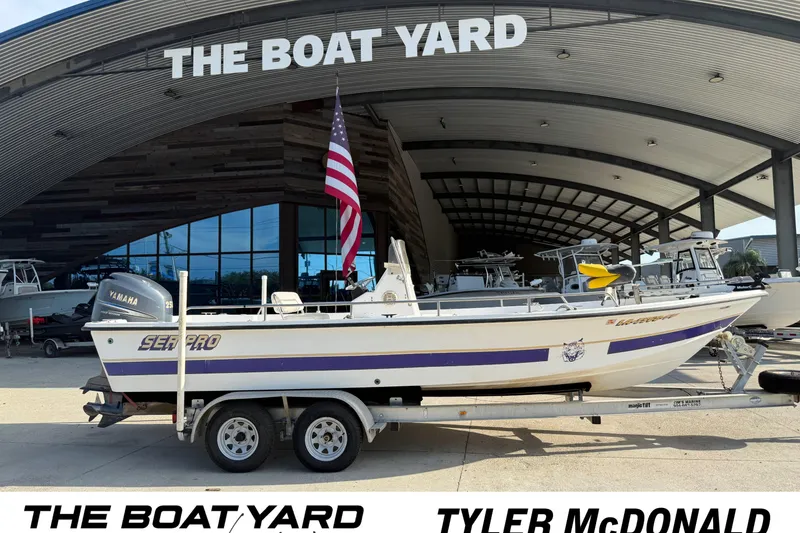 Slide: The Image of 2002 Sea Pro SV2400CC Bay Boat on a trailer in front of a modern building. - 9