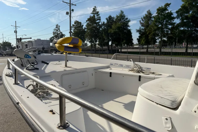 Slide: The Image of 2002 Sea Pro SV2400CC Bay Boat with seating and equipment, parked outdoors. - 12