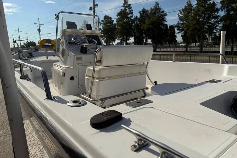 Slide: The Image of 2002 Sea Pro SV2400CC Bay Boat with console and seating, docked under clear skies. - 10
