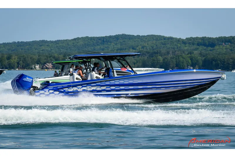 Slide: The Image of 2025 Nor-Tech 390 Sport Center Console boat cruising on a lake with passengers. - 1