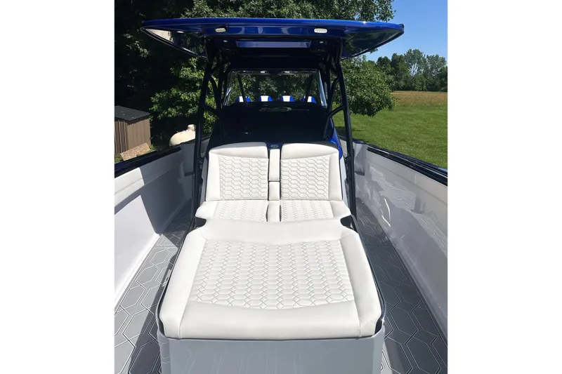 Slide: The Image of 2025 Nor-Tech 390 Sport Center Console boat with luxurious white seating and sleek design. - 4