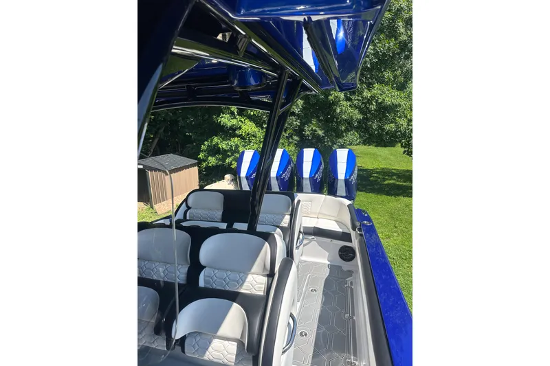 Slide: The Image of 2025 Nor-Tech 390 Sport Center Console with blue accents and multiple outboard engines. - 5