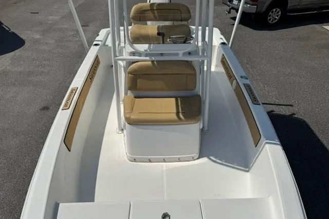 Slide: The Image of 2022 Savannah 190 IS boat with tan seating and white deck, parked on asphalt. - 7