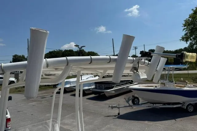 Slide: The Image of Boat docked with rod holders, Savannah 190 IS, 2022 model, under clear blue sky. - 15