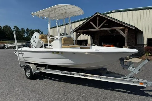 Slide: The Image of 2022 Savannah 190 IS boat on trailer, parked outside a building under clear skies. - 1