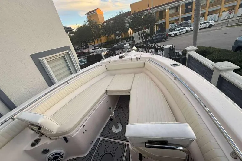 Slide: The Image of 2004 Grady-White Chase 273 boat with spacious seating, docked near a building. - 4