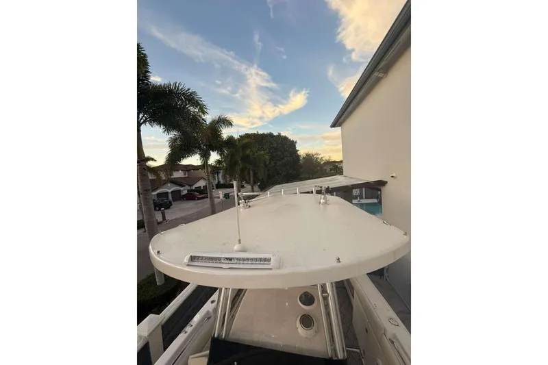Slide: The Image of 2004 Grady-White Chase 273 boat docked near palm trees under a blue sky. - 3