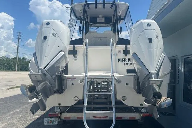 Slide: The Image of 2024 World Cat 295 CC boat with dual outboard motors, rear view. - 2