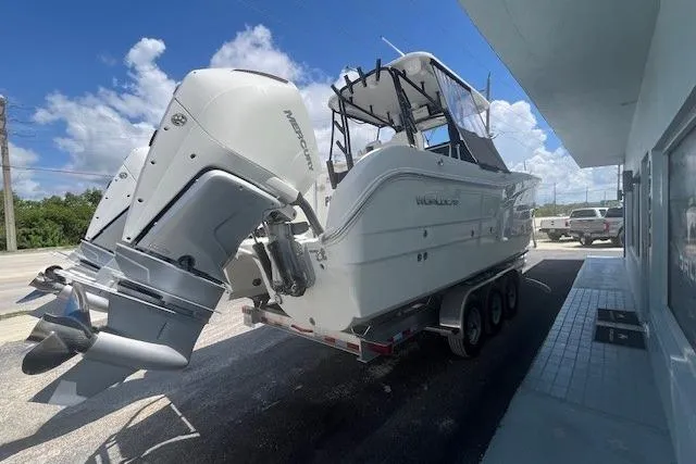 Slide: The Image of 2024 World Cat 295 CC boat on trailer, featuring twin Mercury outboard engines. - 3