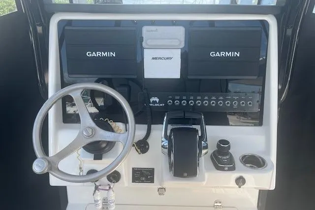Slide: The Image of 2024 World Cat 295 CC boat dashboard with Garmin displays and Mercury controls. - 5