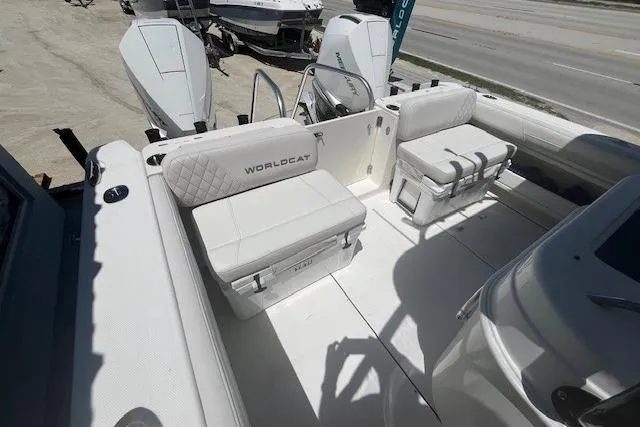 Slide: The Image of 2024 World Cat 295 CC boat interior with white seating and dual outboard motors. - 7