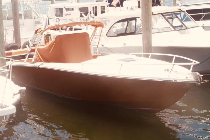 Slide: The Image of 1996 Marlago 35 boat docked in marina, covered with a brown tarp. - 2