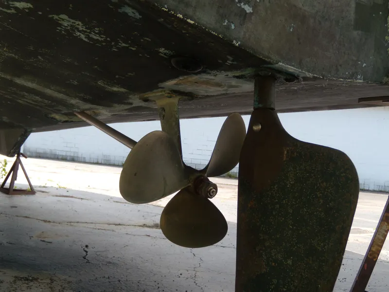 Slide: The Image of Close-up of a boat rudder and propeller beneath the hull of a 1973 Trojan F-32. - 4