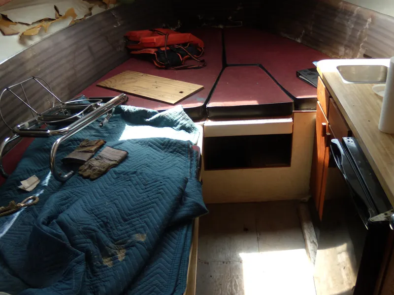 Slide: The Image of Interior of a 1973 Trojan F-32 boat with red cushions and wooden cabinetry. - 7