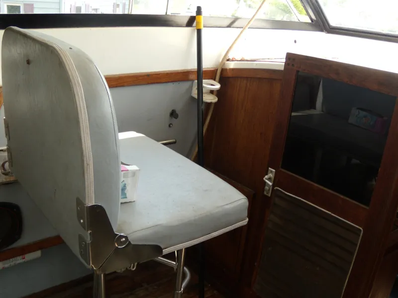 Slide: The Image of The image shows the helm of a 1973 Trojan F-32 with a gray seat and wooden doors. - 13