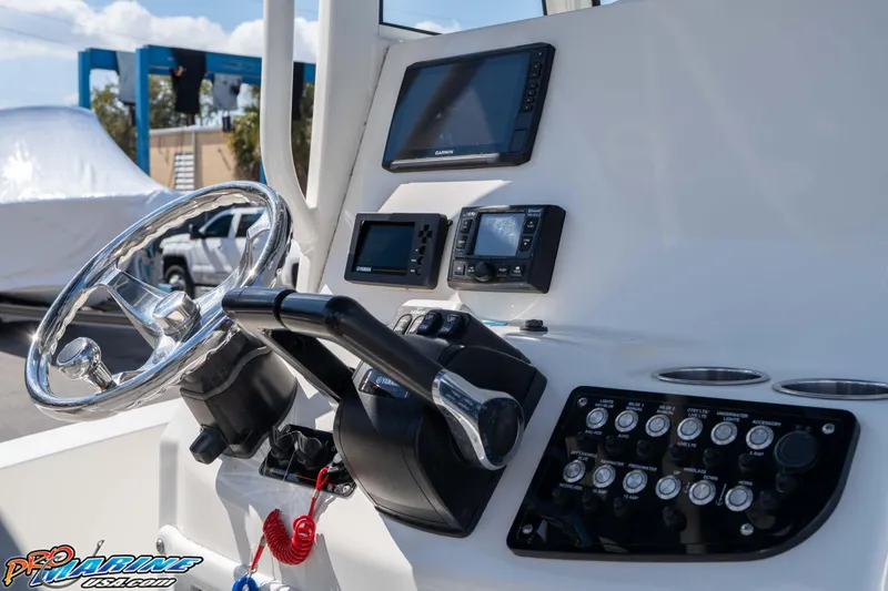 Slide: The Image of 2021 NauticStar 2602 Legacy boat dashboard with steering wheel and electronic controls. - 25