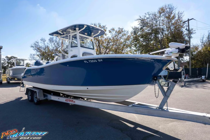 Slide: The Image of 2021 NauticStar 2602 Legacy boat on trailer, blue hull, outdoor setting. - 47