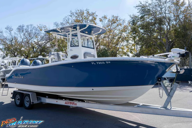 Slide: The Image of 2021 NauticStar 2602 Legacy boat on trailer, blue hull, parked outdoors. - 2