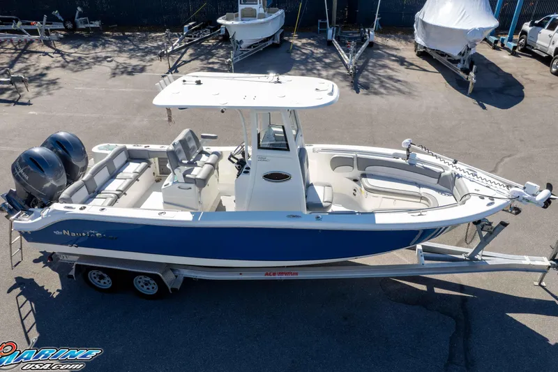 Slide: The Image of 2021 NauticStar 2602 Legacy boat on trailer, featuring dual engines and spacious seating. - 46