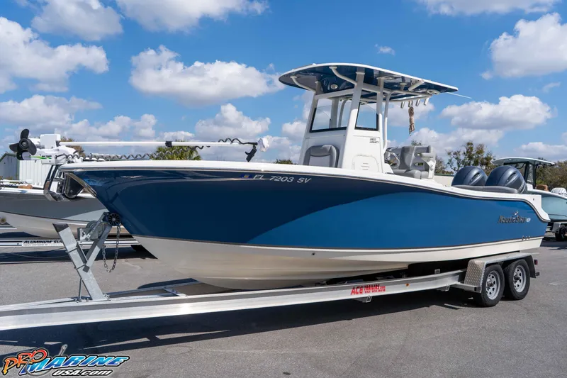 Slide: The Image of 2021 NauticStar 2602 Legacy boat on trailer under blue sky. - 8