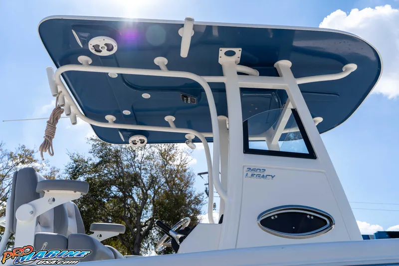 Slide: The Image of 2021 NauticStar 2602 Legacy boat with blue T-top under sunny sky. - 16