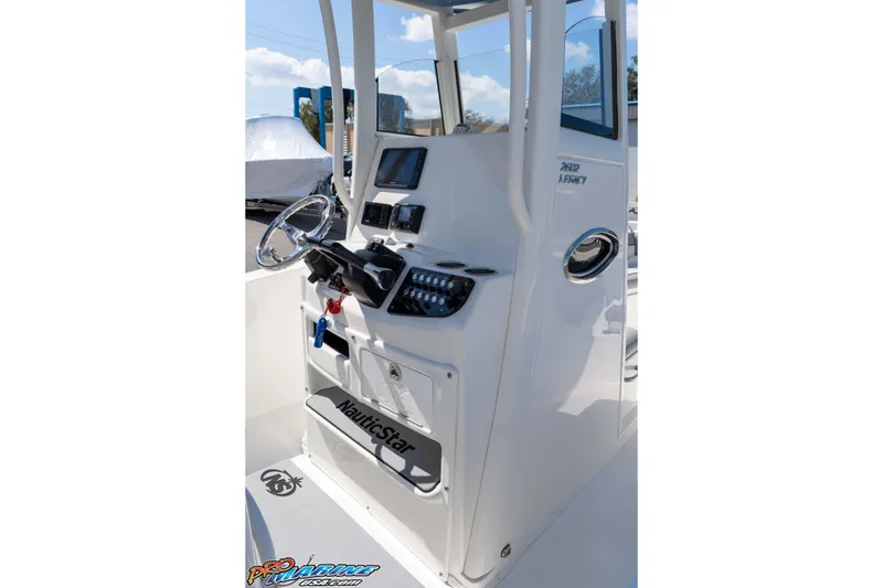 Slide: The Image of 2021 NauticStar 2602 Legacy boat console with steering wheel and controls. - 24