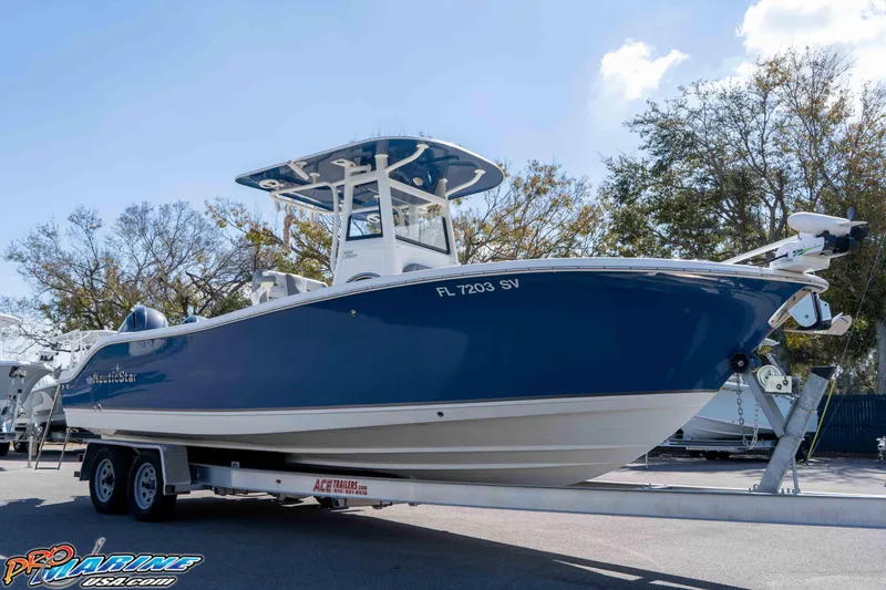 The Image of 2021 NauticStar 2602 Legacy boat on trailer, blue hull, sunny day. - 1