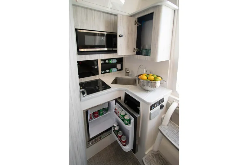 Slide: The Image of Compact kitchen in 2027 Regulator 41 boat with microwave, sink, and fridge. - 11