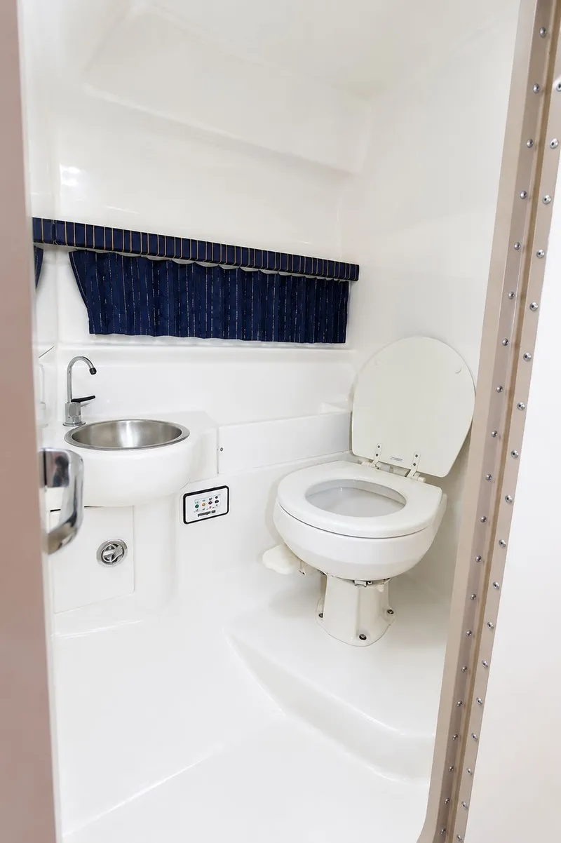 Slide: The Image of The image shows a clean, white bathroom with a toilet and a sink. - 16