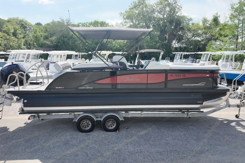 Slide: The Image of 2022 Barletta Corsa 23U pontoon boat on trailer, parked outdoors. - 4