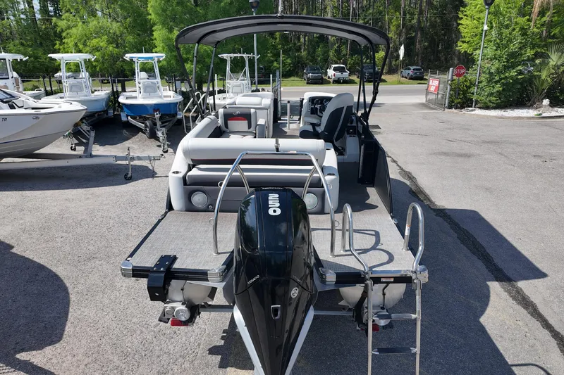 Slide: The Image of 2022 Barletta Corsa 23U pontoon boat with outboard motor, parked on a sunny day. - 6