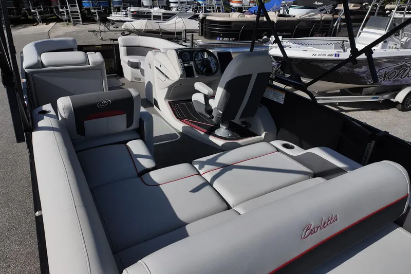 Slide: The Image of 2022 Barletta Corsa 23U pontoon boat interior with plush seating and modern dashboard. - 14
