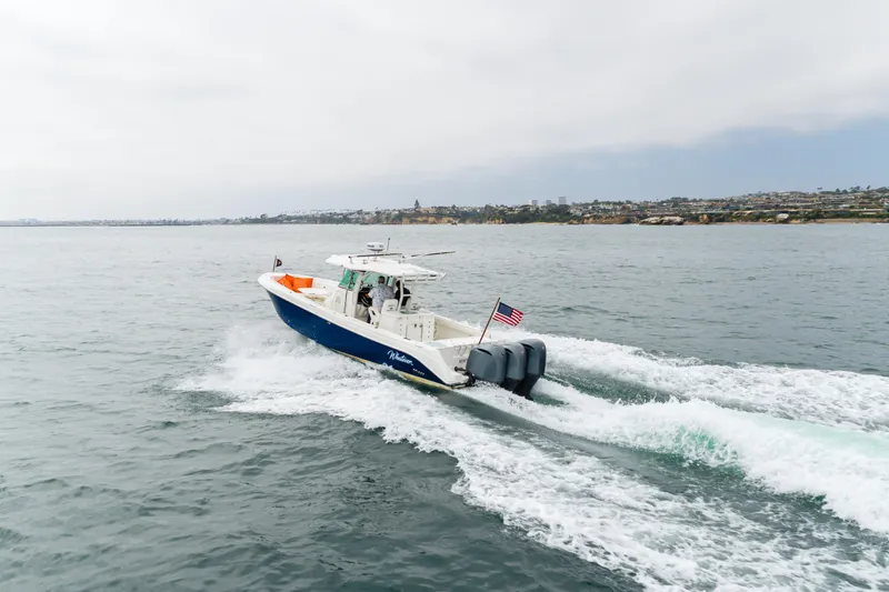 Slide: The Image of 2009 Everglades 350 Center Console boat cruising on open water. - 16