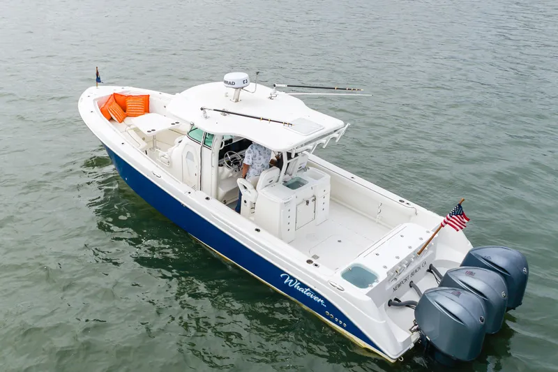 Slide: The Image of 2009 Everglades 350 Center Console boat on water, featuring triple outboard engines. - 27