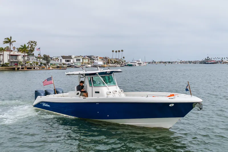 Slide: The Image of 2009 Everglades 350 Center Console boat cruising near waterfront homes. - 21