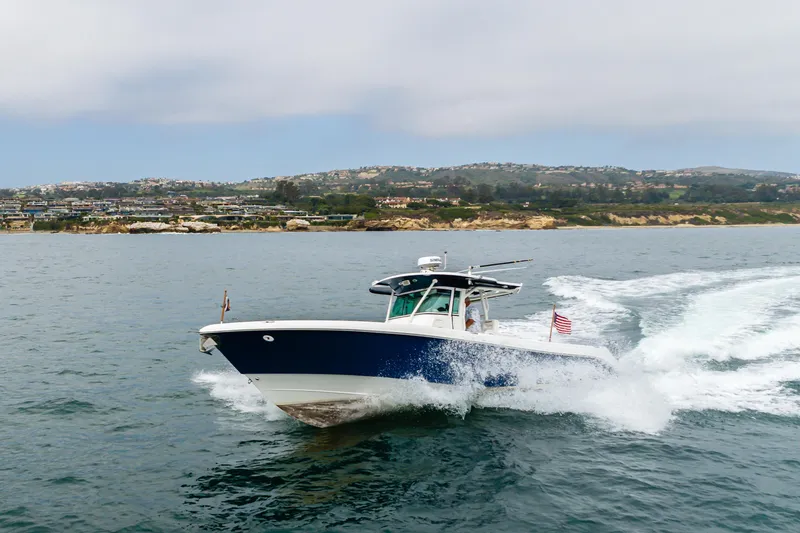 Slide: The Image of 2009 Everglades 350 Center Console boat cruising on open water near scenic coastline. - 17