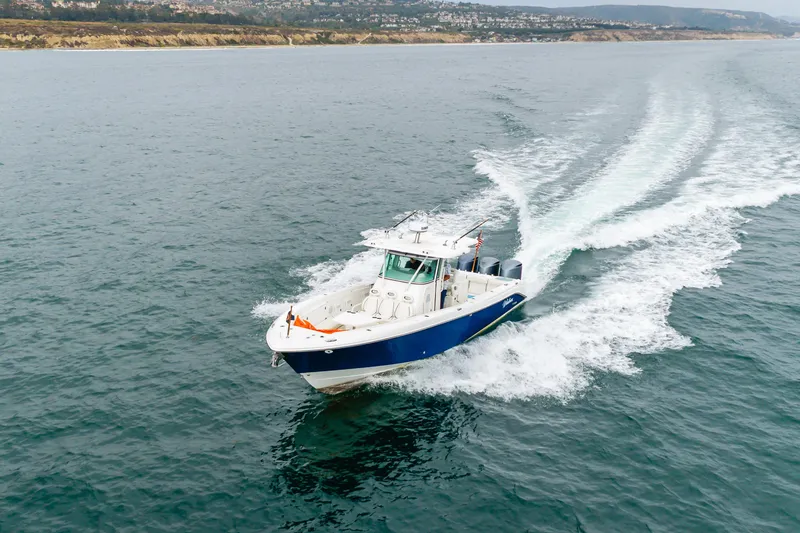 Slide: The Image of 2009 Everglades 350 Center Console boat cruising on open water. - 15