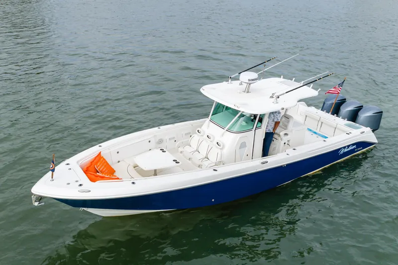 The Image of 2009 Everglades 350 Center Console boat on water, featuring blue hull and triple engines. - 0