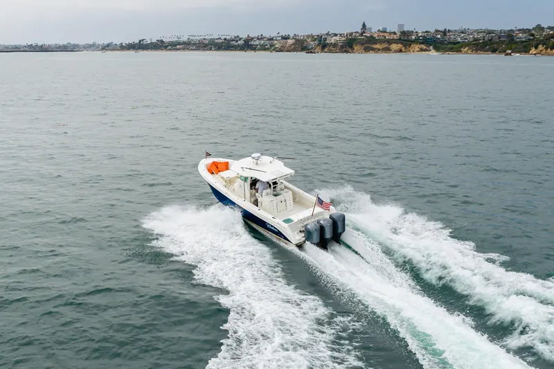 Slide: The Image of 2009 Everglades 350 Center Console boat cruising on open water near coastline. - 18