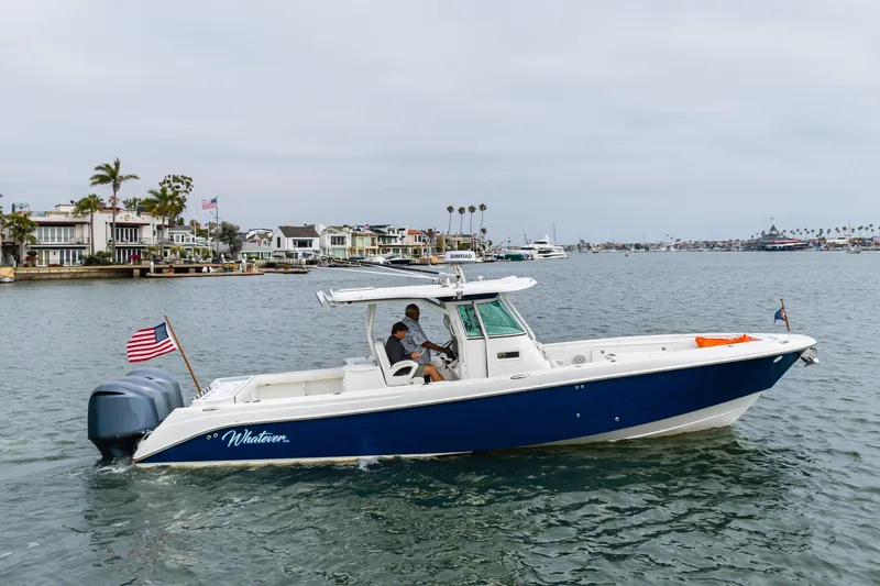 Slide: The Image of 2009 Everglades 350 Center Console boat cruising near waterfront homes. - 20