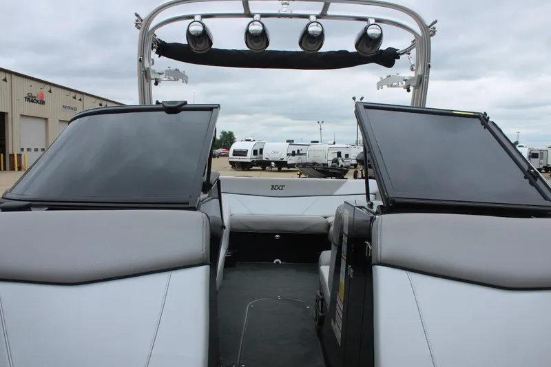 Slide: The Image of 2017 MasterCraft NXT22 boat interior with open windshield, gray seating, and tower speakers. - 35