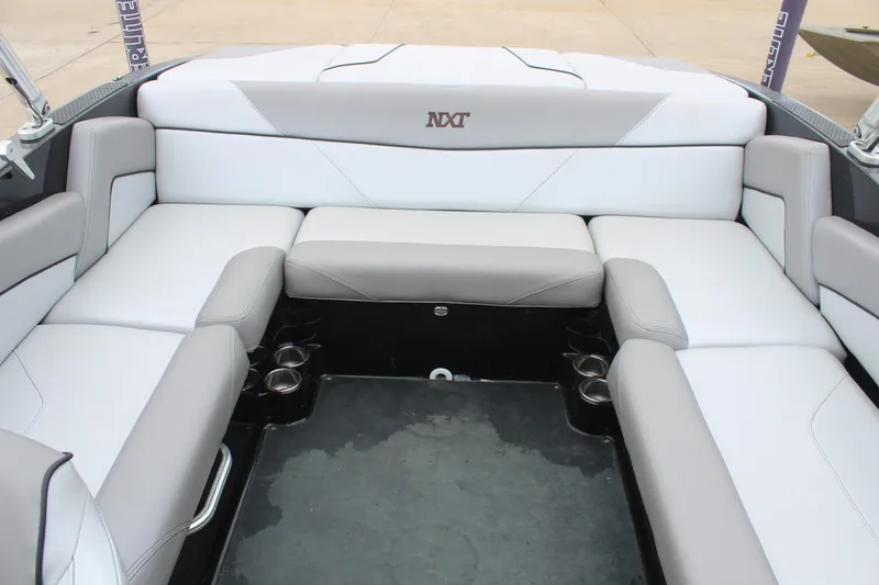 Slide: The Image of 2017 MasterCraft NXT22 boat interior with white and gray seating arrangement. - 17